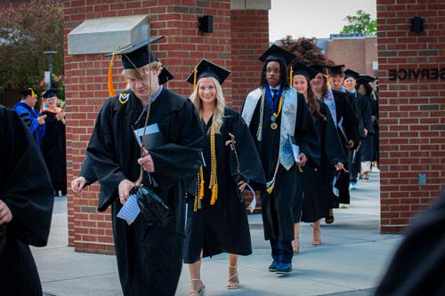 Graduating students walking under the chime tower